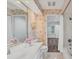 Cozy bathroom featuring floral wallpaper, a vanity, and a glimpse into an adjoining bedroom at 7416 Riverview Dr, Bradenton, FL 34209