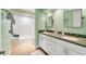 Bathroom with double sink vanity, walk-in shower and green walls at 7416 Riverview Dr, Bradenton, FL 34209
