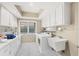 Bright laundry room with front load washer and dryer, folding counter, and sink at 7416 Riverview Dr, Bradenton, FL 34209