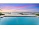 Stunning waterfront view from the pool overlooking the ocean and docks at sunset at 7416 Riverview Dr, Bradenton, FL 34209