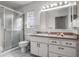 This bathroom features a toilet, vanity, sink, mirror, and tiled shower with glass doors at 807 62Nd W St, Bradenton, FL 34209