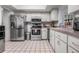 A stainless steel refrigerator and appliances accent the kitchen with tiled floors and white cabinetry at 807 62Nd W St, Bradenton, FL 34209