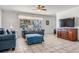 Cozy living room with tile flooring, comfortable blue sofa, and large window at 807 62Nd W St, Bradenton, FL 34209
