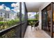 Balcony with black metal railing and a chair overlooking lush landscaping and blue skies at 1001 Benjamin Franklin Dr # 110, Sarasota, FL 34236
