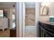 Bathroom with tiled shower featuring a grab bar, vanity with silver framed mirror, and storage at 1001 Benjamin Franklin Dr # 110, Sarasota, FL 34236