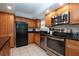 Bright kitchen showcasing wood cabinets, stainless steel appliances, and tile floors at 1001 Benjamin Franklin Dr # 110, Sarasota, FL 34236