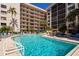 Inviting pool area features lounge chairs and a jacuzzi beside a towering condo building at 1001 Benjamin Franklin Dr # 110, Sarasota, FL 34236