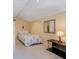 Cozy bedroom with a bed featuring a patterned cover, adjacent to a sleek black console table and a decorative wall mirror at 235 Woodland Dr, Osprey, FL 34229