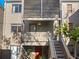 Exterior shot of condo showcasing the walkway and the orange front door, with potted plants and a small balcony at 235 Woodland Dr, Osprey, FL 34229