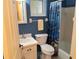 Bathroom with blue walls, white vanity, shower with blue curtain, and a window above the toilet at 3756 Lake Bayshore # 509, Bradenton, FL 34205