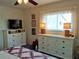 Bedroom with a ceiling fan, plush white bedding, white dresser, and window at 3756 Lake Bayshore # 509, Bradenton, FL 34205