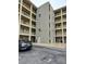 View of the outside of a multi-story apartment building with balconies for each unit and a gray car at 3756 Lake Bayshore # 509, Bradenton, FL 34205