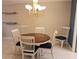 Dining room with a wood table, stylish chairs, and a charming chandelier at 3756 Lake Bayshore # 509, Bradenton, FL 34205
