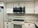 Bright kitchen with white cabinets, stainless steel microwave, and granite countertops at 3756 Lake Bayshore # 509, Bradenton, FL 34205