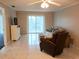 Bright living room featuring tile floors, neutral walls, ceiling fan and sliding glass doors to the outside balcony at 3756 Lake Bayshore # 509, Bradenton, FL 34205