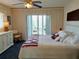 Main bedroom with plush white bedding, nautical decor, white dresser, and view to outdoor balcony at 3756 Lake Bayshore # 509, Bradenton, FL 34205