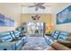 Bright living room with high ceilings, comfortable blue furniture, and sliding doors to a balcony at 755 Village Cir # 203, Venice, FL 34292