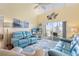 Bright living room with high ceilings, comfortable blue furniture, and sliding doors to a balcony at 755 Village Cir # 203, Venice, FL 34292