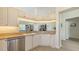 Well-lit kitchen featuring white cabinetry, stainless steel appliances, and elegant countertops and stylish backsplash at 7703 Whitebridge Gln, University Park, FL 34201