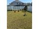 Spacious backyard is enclosed by a white vinyl fence and has lush green grass with several decorative planters at 10923 Blue Magnolia Ln, Parrish, FL 34219