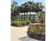 A white gazebo sits among palm trees and manicured hedges and flowering plants at 10923 Blue Magnolia Ln, Parrish, FL 34219