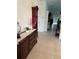 Hallway with neutral tile flooring, features a sideboard with decor and view to a living space at 10923 Blue Magnolia Ln, Parrish, FL 34219