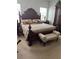 Main bedroom has large bed with upholstered bench and side table at 10923 Blue Magnolia Ln, Parrish, FL 34219