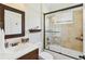 Well-appointed bathroom with a dark wood vanity, shower and tub combo, and stylish wallpaper at 14614 Newtonmore Ln, Lakewood Ranch, FL 34202