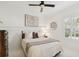 Comfortable bedroom featuring white wainscoting, a ceiling fan, and bright neutral decor at 14614 Newtonmore Ln, Lakewood Ranch, FL 34202