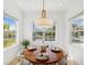 Bright breakfast nook with a round table surrounded by windows, offering a view of the pool area at 14614 Newtonmore Ln, Lakewood Ranch, FL 34202