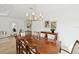 Formal dining room featuring a large wooden table, elegant chandelier, and neutral decor at 14614 Newtonmore Ln, Lakewood Ranch, FL 34202