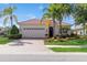 Beautiful single-Gathering home with mature trees, a tile roof, and a paved driveway at 14614 Newtonmore Ln, Lakewood Ranch, FL 34202