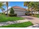 Charming single-story home with a red tile roof, a well-manicured lawn, and lush landscaping at 14614 Newtonmore Ln, Lakewood Ranch, FL 34202