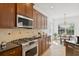 Modern kitchen featuring stainless steel appliances, custom cabinets and backsplash, and adjacent breakfast nook at 14614 Newtonmore Ln, Lakewood Ranch, FL 34202
