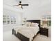 Spacious main bedroom with tray ceiling, ceiling fan, and bright windows with shutters at 14614 Newtonmore Ln, Lakewood Ranch, FL 34202