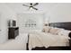 Comfortable main bedroom with tray ceiling, ceiling fan, and bright windows with shutters at 14614 Newtonmore Ln, Lakewood Ranch, FL 34202