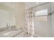 Bright bathroom featuring granite countertops, framed mirror, decorative shower curtain, and tub with window at 330 Caruso Pl, Sarasota, FL 34237