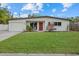 Inviting single-story home featuring a well-manicured lawn, vibrant red front door, and an attached garage at 330 Caruso Pl, Sarasota, FL 34237