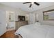Cozy bedroom with hardwood floors, ceiling fan, walk in closet, and ensuite bathroom with granite countertops at 330 Caruso Pl, Sarasota, FL 34237