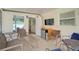 Cozy screened patio with comfortable seating, a mini-fridge, and a wall-mounted television at 330 Caruso Pl, Sarasota, FL 34237