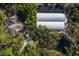 Aerial view showcases home with pool and greenhouses surrounded by lush greenery and pond, offering privacy at 3395 Hardee Dr, Venice, FL 34292