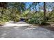 Exterior view of a home surrounded by lush greenery and trees, featuring a wide driveway and inviting entrance at 3395 Hardee Dr, Venice, FL 34292