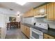 Kitchen area next to a dining area, featuring wood cabinets and appliances at 3395 Hardee Dr, Venice, FL 34292