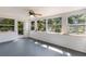 Bright sunroom with multiple windows offering scenic outdoor views and a ceiling fan at 3395 Hardee Dr, Venice, FL 34292
