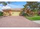 Inviting residence featuring a paver driveway, manicured landscaping, and a barrel tile roof at 4850 Sweetshade Dr, Sarasota, FL 34241