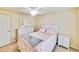 Bedroom with white furniture, ceiling fan, carpet flooring, and coral-themed bedding at 6705 Grand Estuary Trl # 201, Bradenton, FL 34212