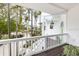 Balcony view showcases palm trees, lush landscaping and a white railing at 6821 Longboat S Dr, Longboat Key, FL 34228