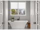 Bright bathroom with modern fixtures, a freestanding tub, and a window offering views of the surrounding landscape at 6821 Longboat S Dr, Longboat Key, FL 34228