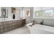 Bathroom featuring a freestanding tub, dual vanities, modern lighting, and large window with views of the surrounding landscape at 6821 Longboat S Dr, Longboat Key, FL 34228