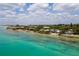 Picturesque coastal homes line the shore with vibrant turquoise waters and lush vegetation at 7314 Point Of Rocks Rd, Sarasota, FL 34242